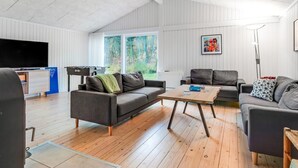 Een moderne woonkamer met een bank, salontafel en een flatscreen televisie.