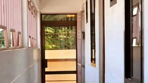 A narrow hallway with a door leading to a balcony. - Otakef Motel  (Arusha)