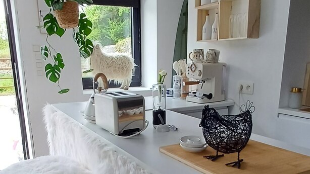A modern kitchen with a white island, wooden countertop, and bar stools. - Tiny cottage in beautiful Wallonia (Sombreffe)