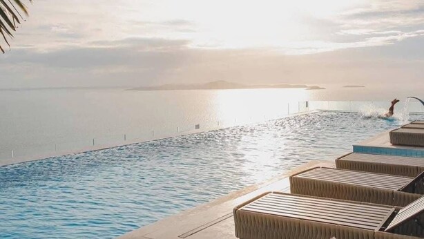An infinity pool with lounge chairs and a view of the sea at sunset. - CopacabanaJomtien Condo PrivatePool CBJ1 (Pattaya)