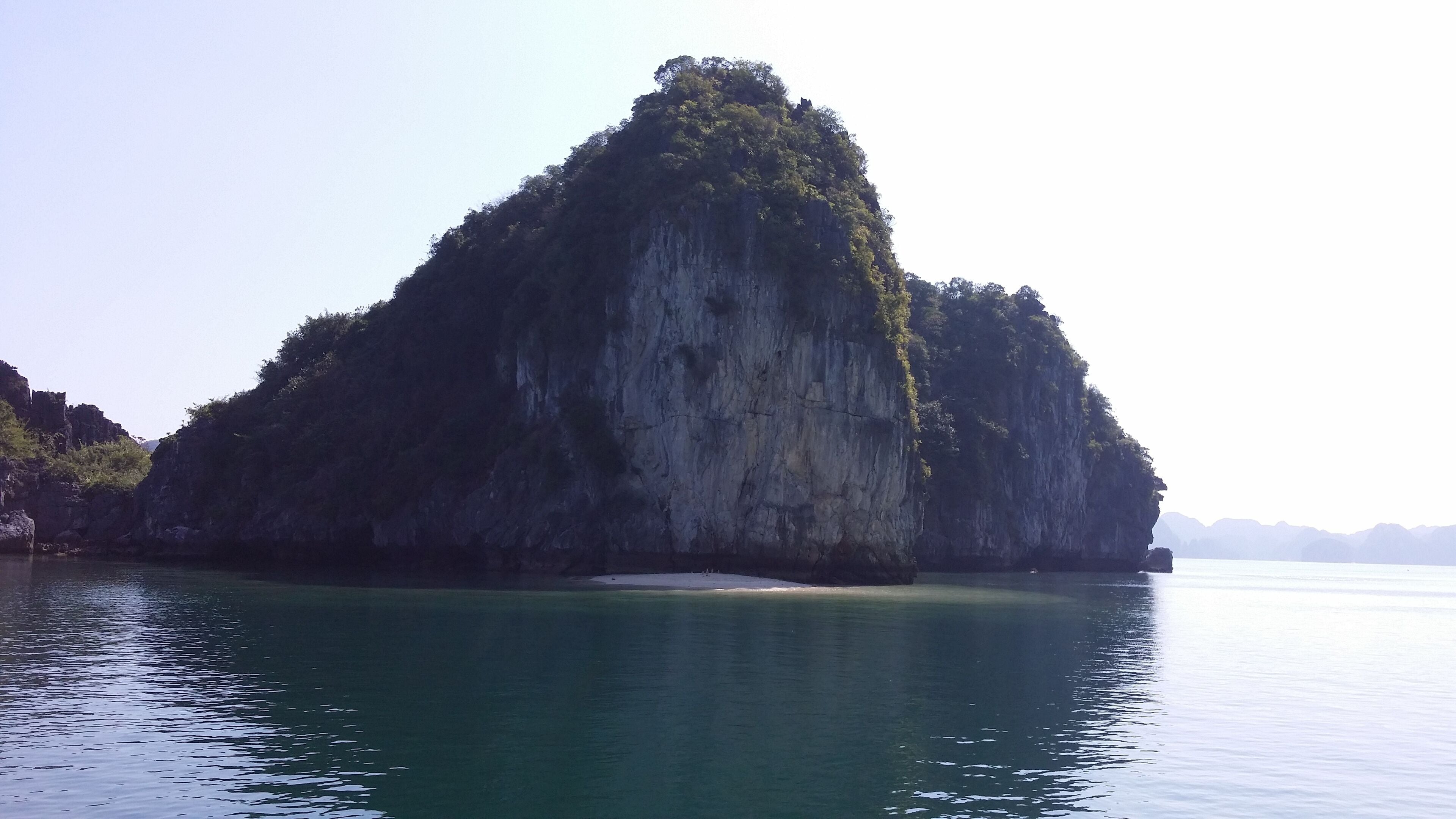 A large, isolated limestone island surrounded by calm water.