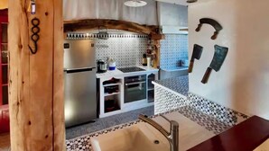 A kitchen with a wooden ceiling, a sink, and a tiled backsplash. - LE GÎTE DU BOIS DE L'HIVER, large character property at the foot of the Puy-de-Dôme mountains (Ceyssat)