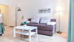 A modern living room with a grey sofa, a white coffee table, and a floor lamp.