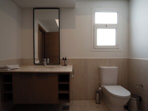 A bathroom with a sink, mirror, toilet, and a window. - BirdNest - Mivida New Cairo (New Cairo)