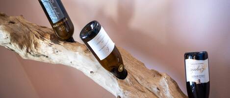 Three wine bottles on a branch.