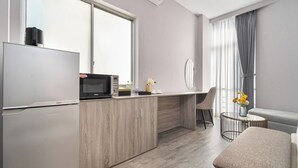 Ett modernt kök med kylskåp, mikrovågsugn och en liten matplats med en stol och ett bord.