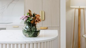 A white marble countertop with a clear glass vase containing flowers.