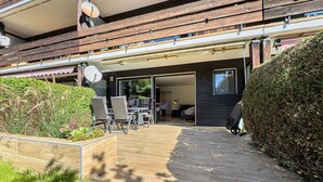 Et moderne hus med en terrasse, udendørs møbler og en parabolantenne.