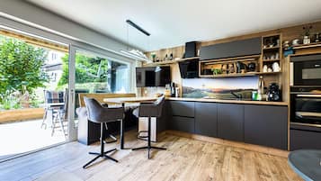 Eine moderne Küche mit großem Fenster, Holzboden und integriertem Backofen.