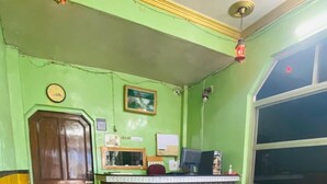 A reception area with a desk, a sofa, and a few chairs. - Prashant Residency (Haridwar)