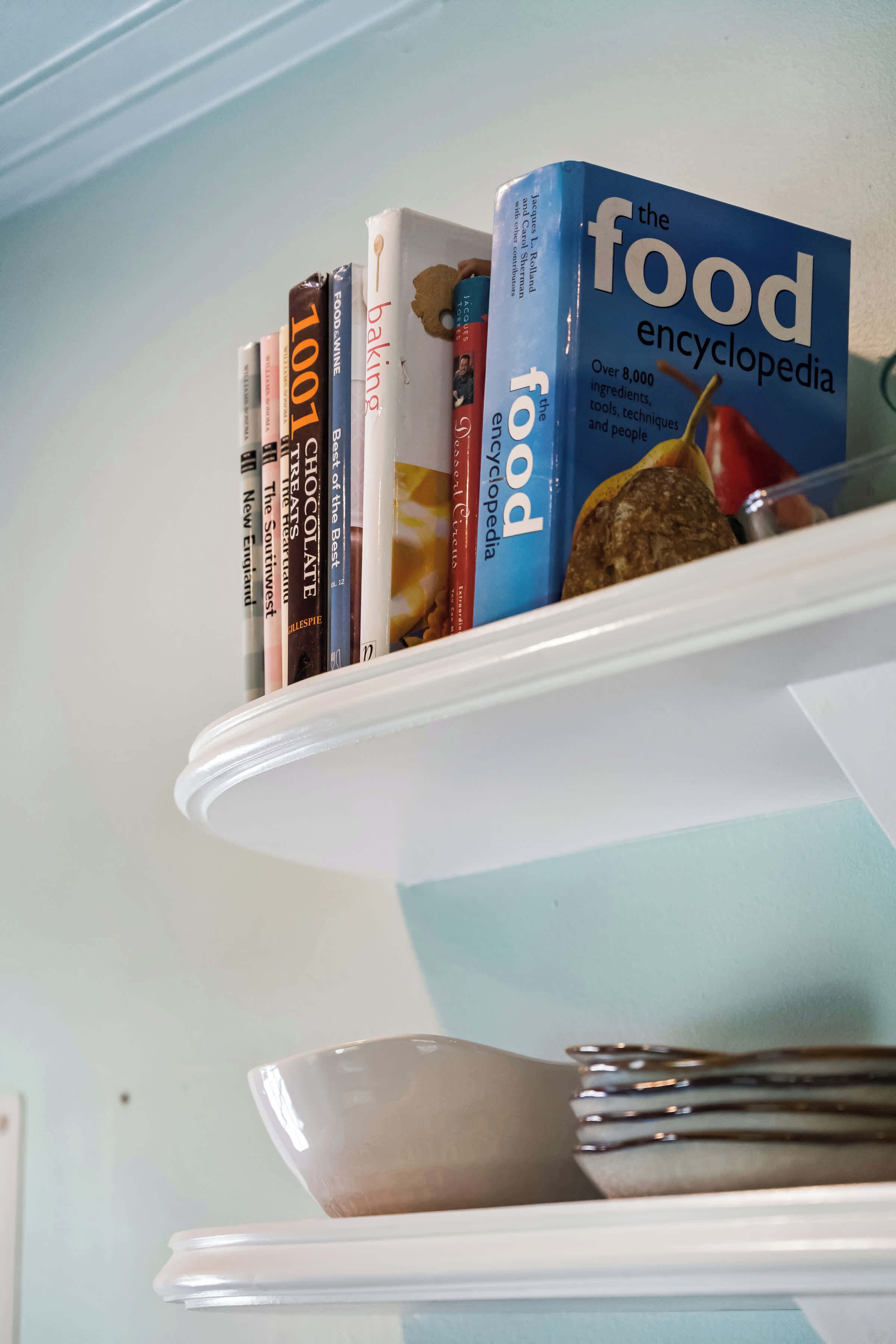 A shelf with books and a spatula.
