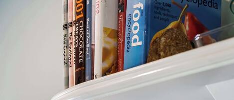 A shelf with books and a spatula.