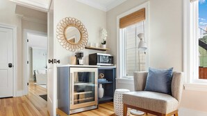 Una cocina moderna con microondas integrado, refrigerador con puerta de vidrio y piso de madera.