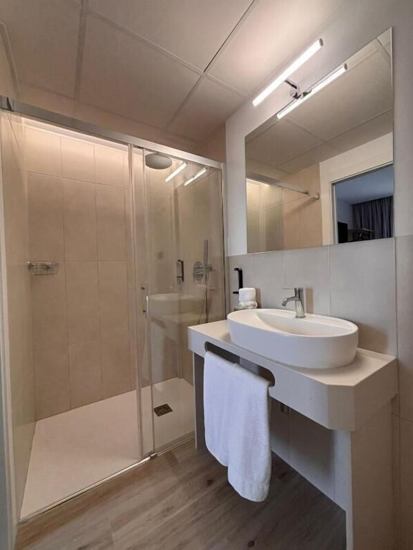 A modern bathroom with a glass-enclosed shower, a white sink, and a large mirror. - Hostal Hs Puerto Lumbreras (Puerto Lumbreras)