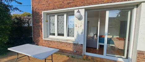 A brick house with a sliding glass door leading to a living area.