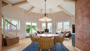 A spacious dining area with a round table, four wooden chairs, and a blue rug. - Vacation home "Eos" on Lake Tollensesee in Penzlin Wustrow (Penzlin)
