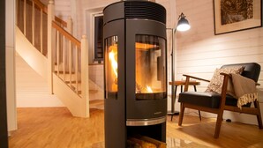 A modern living room with a wood-burning stove, a staircase, and a cozy seating area. - Vacation home "Phoebe" on Lake Tollensesee in Penzlin Wustrow (Penzlin)