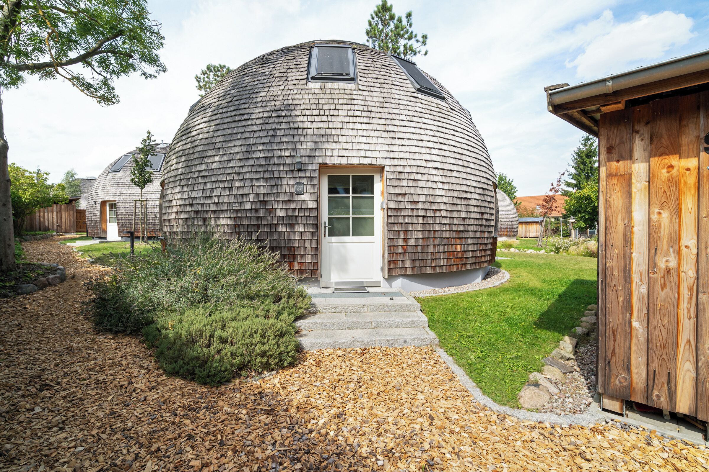 A dome-shaped building with a wooden exterior, a door, and a small window.