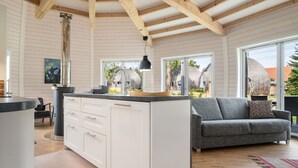A modern kitchen with white cabinets, a central island, and large windows. - Vacation home "Phoebe" on Lake Tollensesee in Penzlin Wustrow (Penzlin)