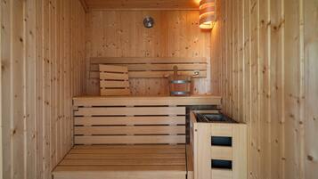 A wooden sauna with benches and a steam shower.