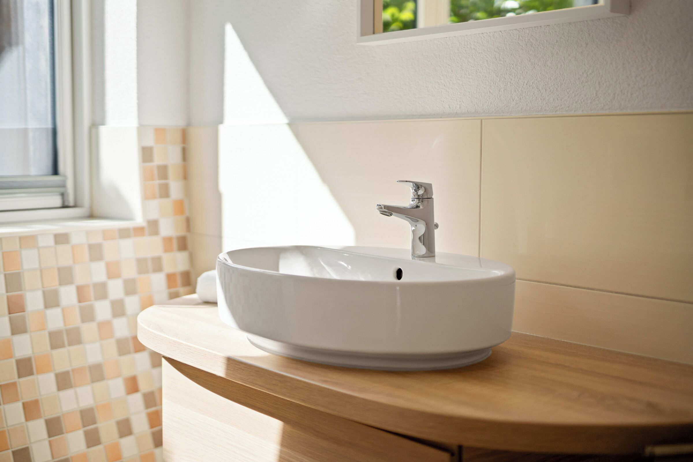 Un baño con un lavamanos blanco, una encimera de madera y un salpicadero de azulejos.