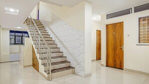 Un intérieur moderne avec un escalier, une porte en bois et une fenêtre.