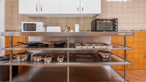 Une cuisine avec des meubles blancs, un four à micro-ondes, un grille-pain et une cuisinière.