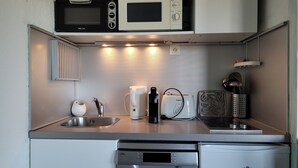 A compact kitchen with a microwave, coffee maker, and toaster. - Renovated studio for 4, valley view, near slopes (Pra-Loup)