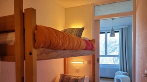 A bunk bed room with a window and a radiator. - Renovated studio for 4, valley view, near slopes (Pra-Loup)