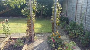 A garden with a wooden arbor, raised flower beds, and a variety of plants. - Great base for a Yorkshire adventure (Malton)