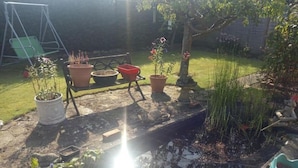 A garden with a pond, potted plants, and a swing set. - Great base for a Yorkshire adventure (Malton)