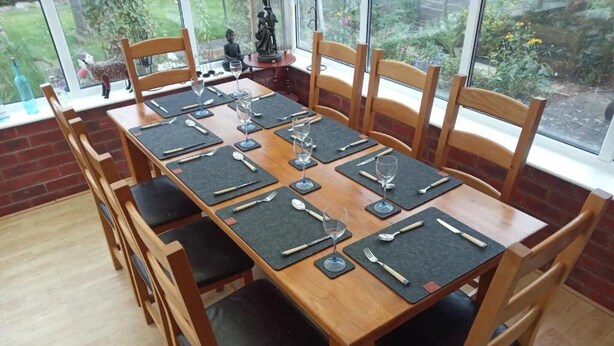 A dining table set with chairs, a statue, and a view of greenery outside. - Great base for a Yorkshire adventure (Malton)