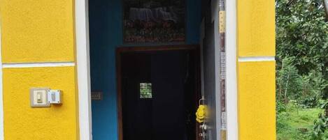 A yellow building with a red mat leading to a dark interior.