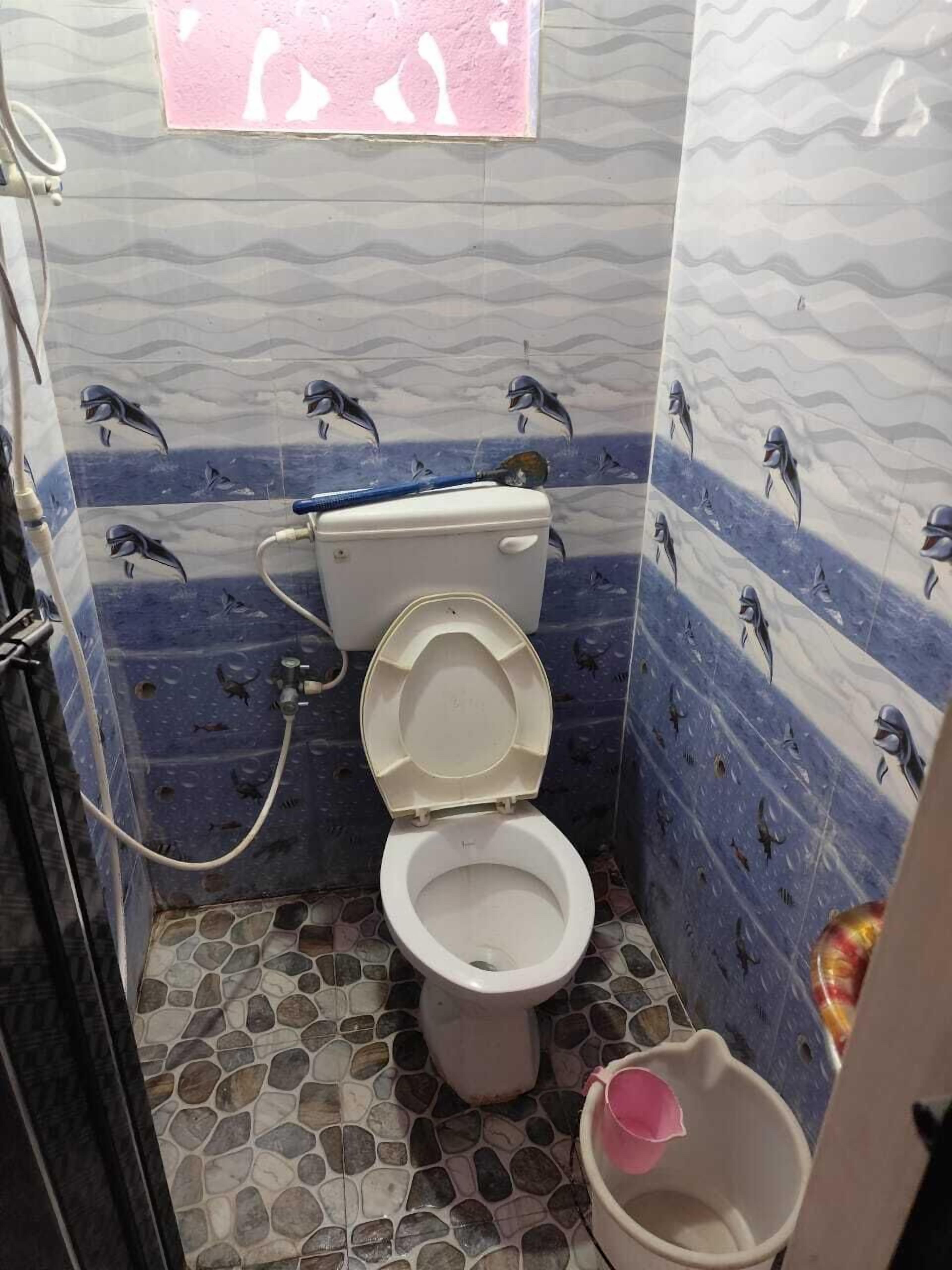 A bathroom with a toilet, a shower, and a sink.