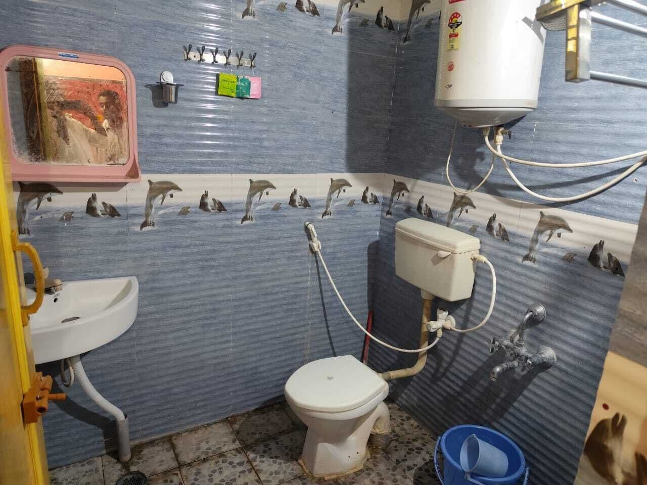 A small, compact bathroom with a toilet, sink, and shower.