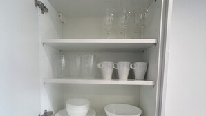 Una cocina con armarios blancos, un tostador y un lavamanos.