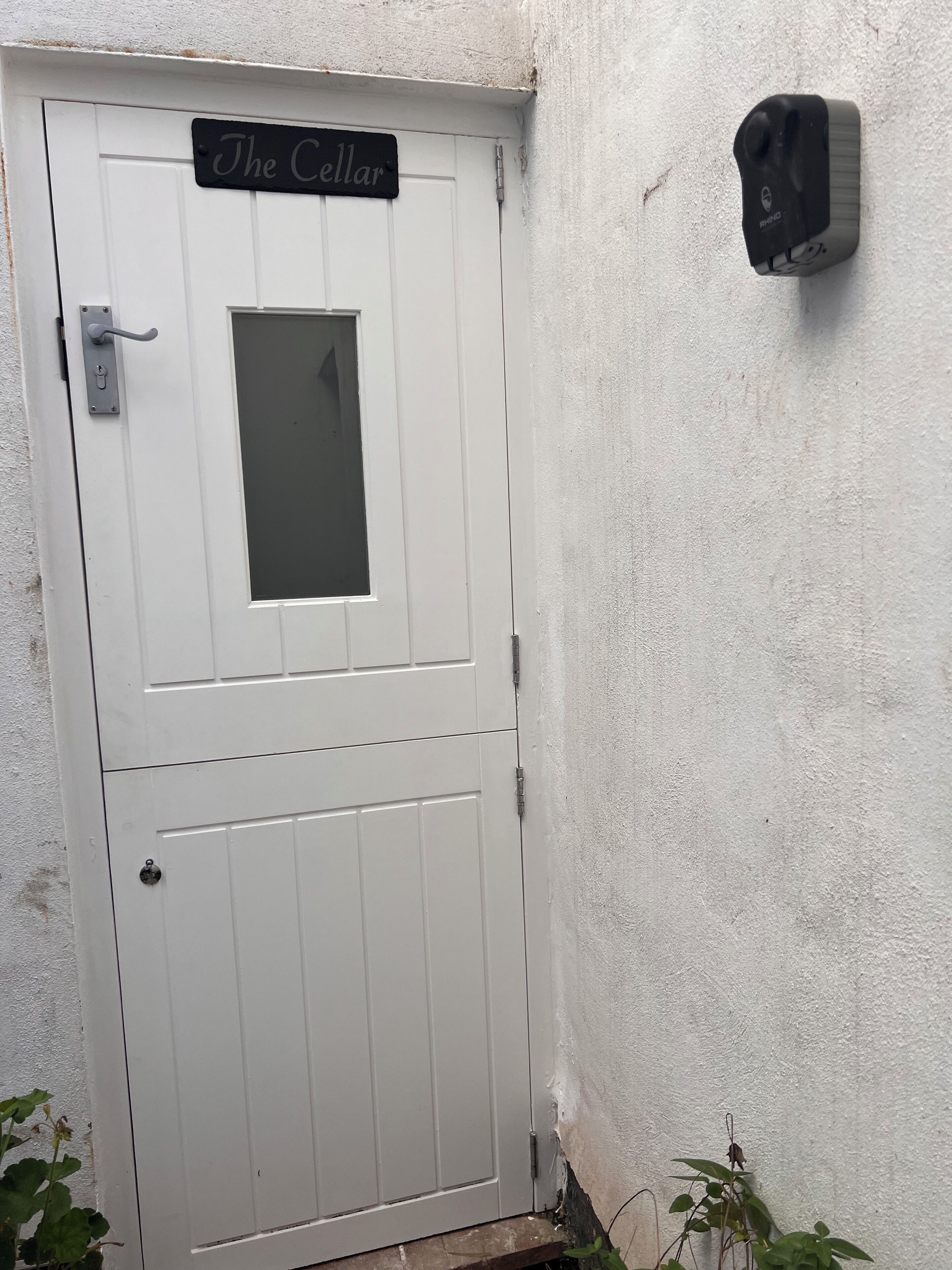 A white door with a small window and a sign above it that reads "The Cellar."