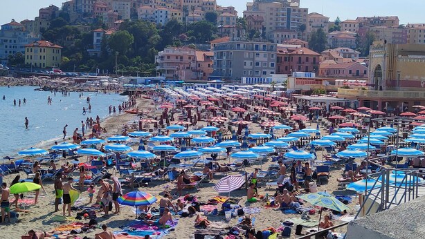 A crowded beach with numerous umbrellas and people sunbathing. - Hotel Al Porto (Imperia)