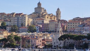 A coastal cityscape with a prominent church and residential buildings. - Hotel Al Porto (Imperia)