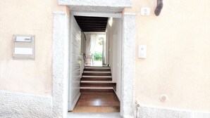 A narrow stairway leading to a landing with a door on the right. - Villa Magnolia Como (Como)
