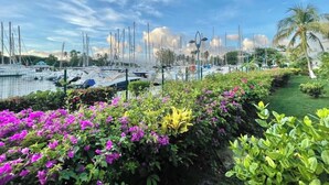 A marina with boats docked, surrounded by vibrant flowers and greenery. - Coconut Lodge - Marina des Trois-ilets-T1 (Les Trois-Îlets)