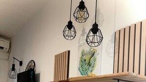A room with wooden shelves, a black stool, and a wooden table. - Coconut Lodge - Marina des Trois-ilets-T1 (Les Trois-Îlets)