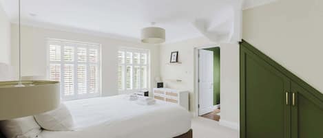 Une chambre à coucher avec un lit, une lampe de chevet, une commode et une armoire verte.