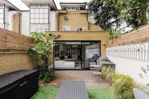 A modern house with a patio, a white sofa, and a grill area.