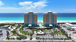 A hotel with two prominent towers, a parking area, and a beach view. - 4 BR En Soleil Directly on Gulf, 5th floor unit with the best views!! (Panama City Beach)