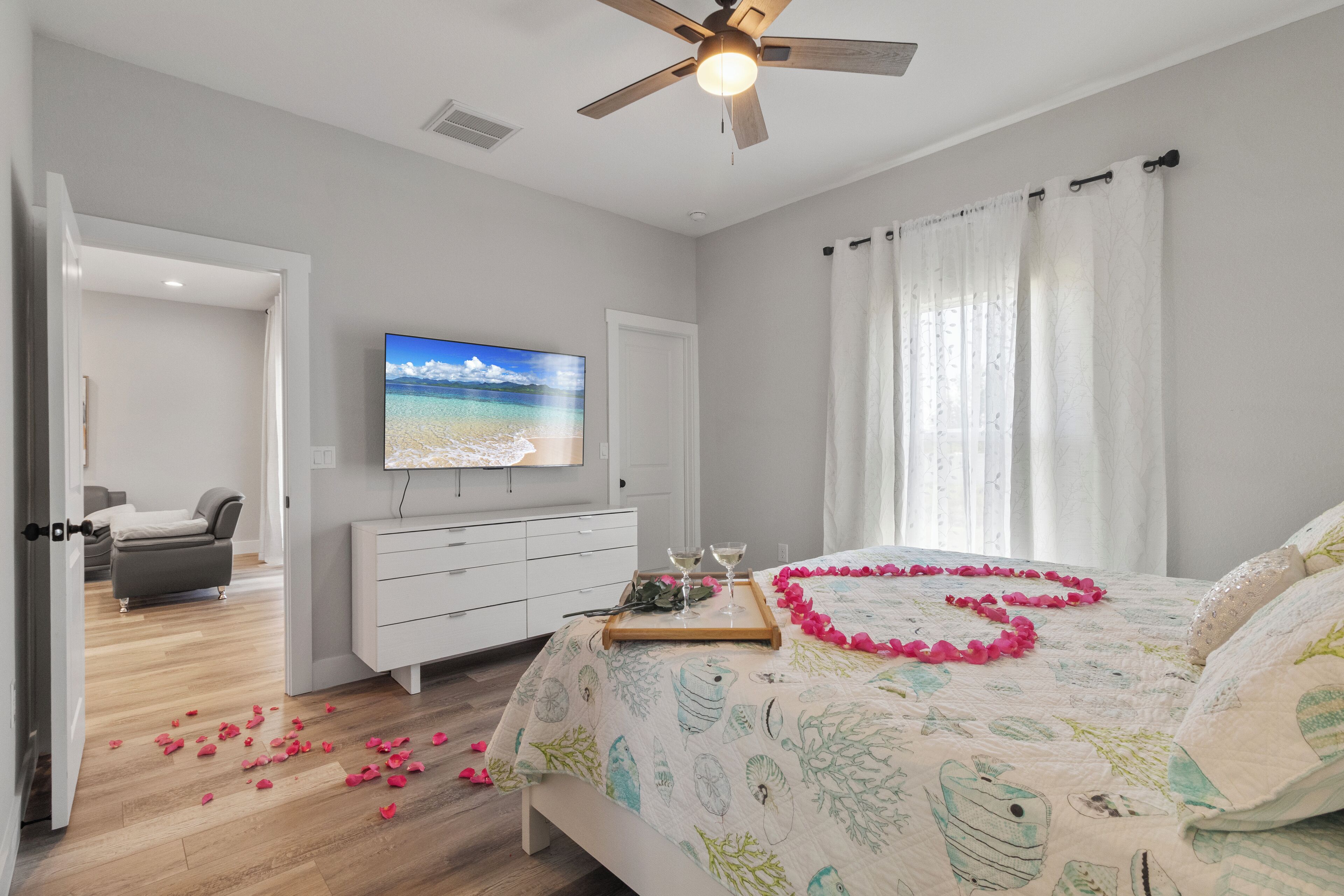 A bedroom with a bed, a TV, a desk, and a chair.