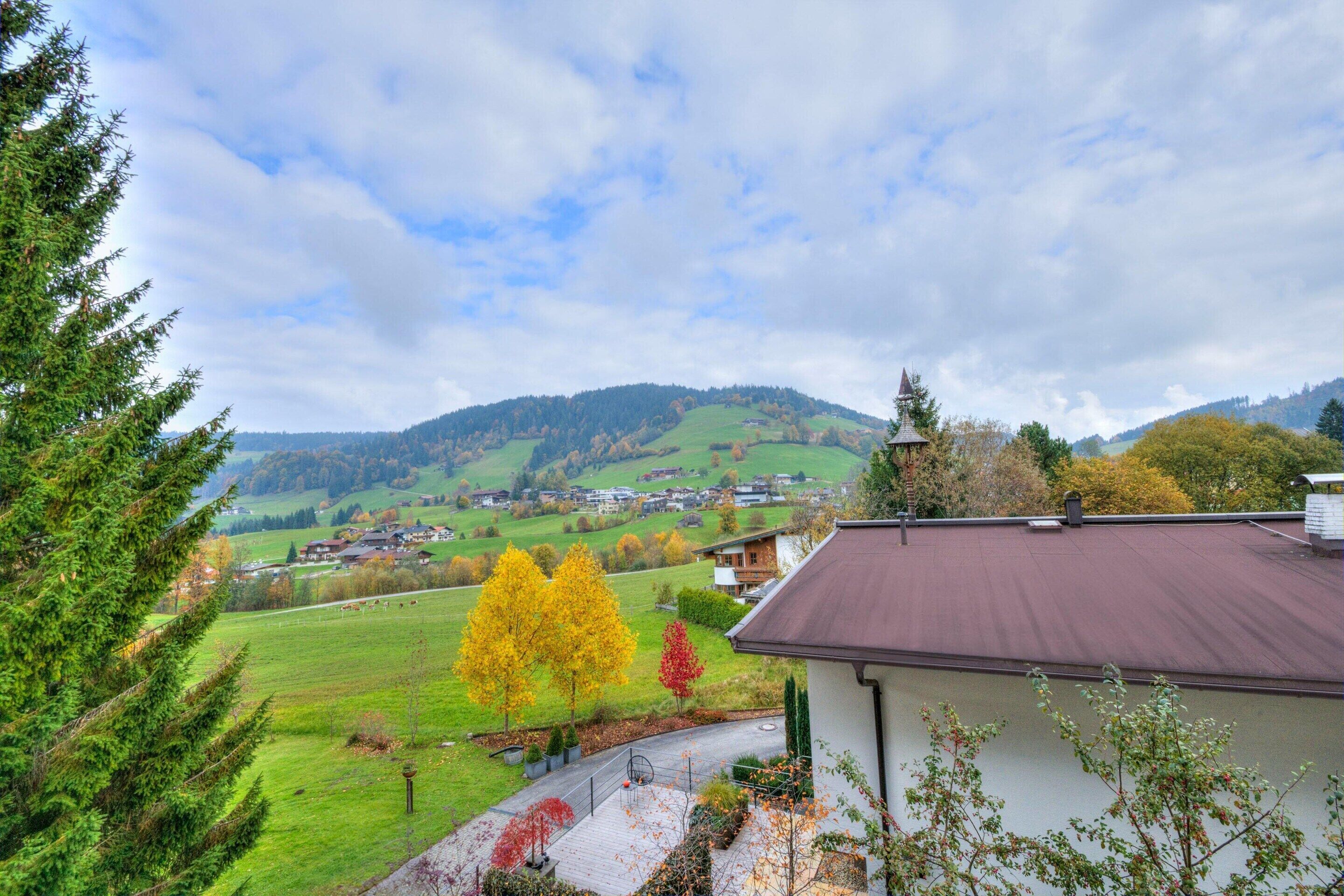 Vista de un paisaje rural con una casa y una iglesia al fondo.