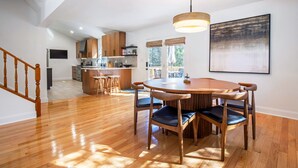 A spacious kitchen with wooden cabinets, a central island, and a dining area with a round table and chairs. - Peak Seasons at Massanutten (Mc Gaheysville)