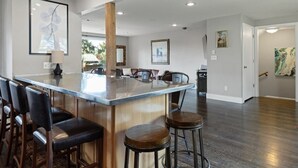 A modern kitchen with a central island, bar stools, and a dining area. - Bluebird Day - Brooks House, Experience comfort in the spacious 3200 sqft, Hot tub, Pet friendly! (Bend)