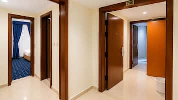 A hotel corridor with wooden doors, a visible room number 700, and a blue patterned carpet.